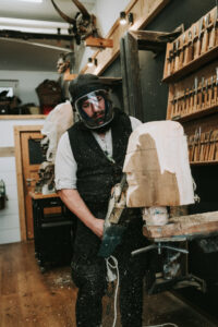 Sebastian Eder formt eine Maske in der Werkstatt